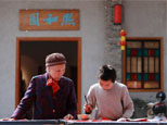 一位小孩為老婆婆寫揮春，并禮贈，老婆婆耐心等待，長幼之情，一紙傳承。網友“生命力”攝
