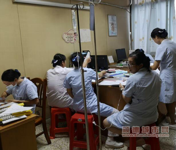 廖秀一邊打著點滴，一邊完成病人的護理日記（醫院供圖）.jpg