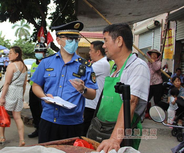 執法人員跟流動攤販講解相關管理規定.jpg