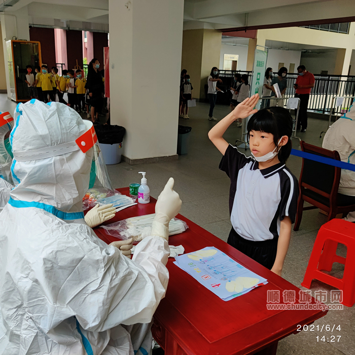 做完核酸檢測的小女孩像醫(yī)護人員敬禮.jpg