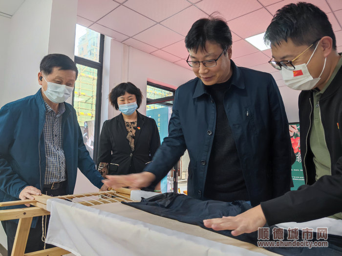 眾人一同觀賞示范基地新搭成的繡架，并對精美的繡品贊不絕口.jpg