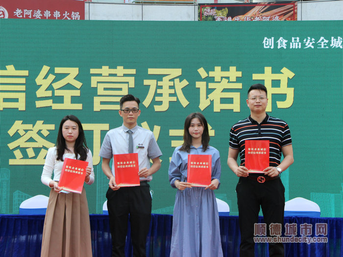商戶代表們在推進會現(xiàn)場簽署誠信經(jīng)營承諾書。.jpg
