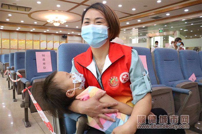 吳葉群志愿者主動幫助前來打疫苗的63歲田爺爺抱著孫女，孩子在溫暖的懷里睡的香甜.JPG