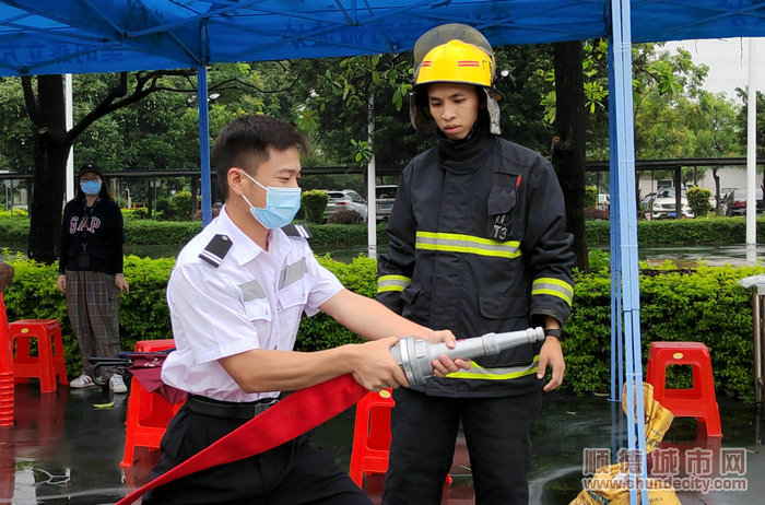 在場人員認真觀看并參與練習消防器材演練.jpg