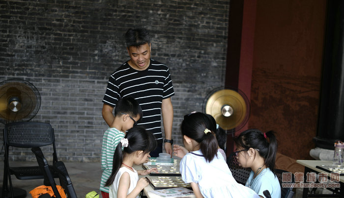 象棋老師圍觀學生下棋，被逗笑。.JPG
