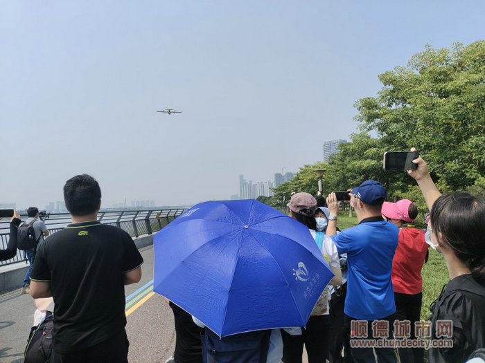 無人機起飛，采風團成員拿出手機“拍照紀念”。.jpg