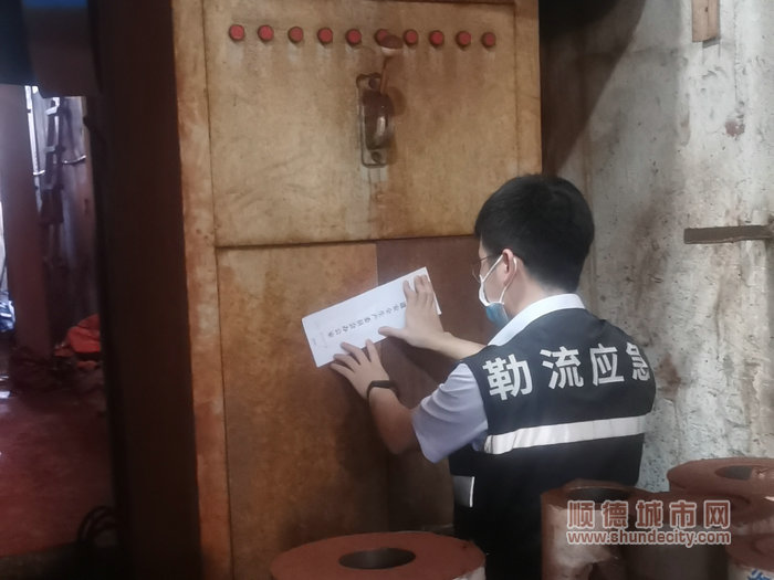 執法人員對違規設備貼封條。.jpg
