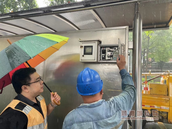執(zhí)法辦工作人員對檢查公交站廣告燈箱控制箱，避免漏電1_副本.jpg
