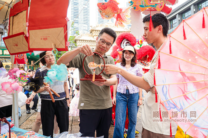 張常委跟著醒獅的引領(lǐng)來到市集觀賞非遺周邊文創(chuàng).jpg
