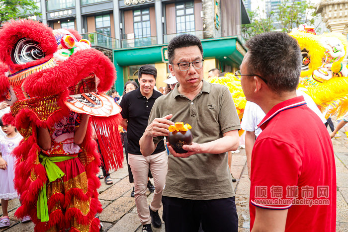 張常委跟著醒獅的引領(lǐng)來到紅米酒攤位.jpg